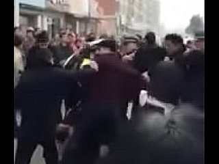 Donna cinese ha messo fuori i suoi pantaloni encircling lotta con i poliziotti